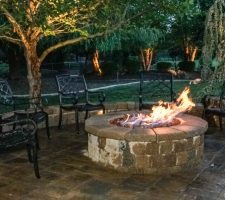 metal outdoor furniture positioned around lit fire pit